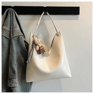 Detail of cream white Hobo shoulder bag with cute teddy bear charm and fashion embroidery