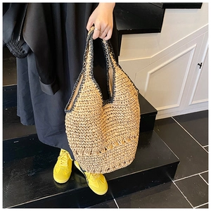 Detailed macro view of beige handmade woven hobo bag with contrast black trim detailing