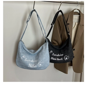 Détail de sacs bandoulière demi-lune gris avec broderie d'animaux et bandoulières réglables