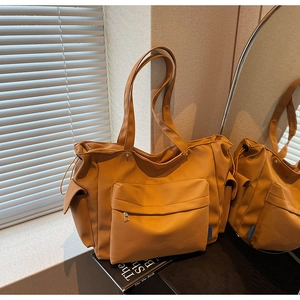 Detail of a large yellow tote bag with front zipper pocket and spacious side compartments
