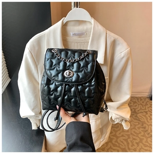 Detail of star-quilted black leather mini backpack with chain strap and metal lock