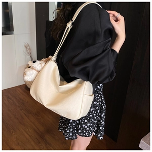 Detail of soft lychee pattern leather shoulder bag with cute plush puppy charm