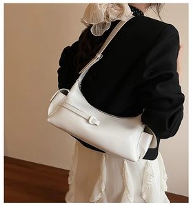 Sac sous le bras en cuir blanc avec poches doubles et boucle, porté par un mannequin
