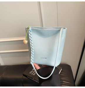 Detail of light blue lychee pattern bucket bag with wood bead and woven strap
