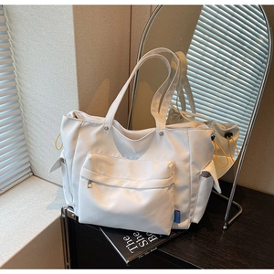 Detail of white large tote bag with yellow drawstring and front zipper pocket