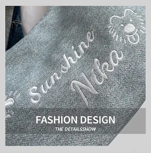 Détail du sac en jean bleu clair avec broderie de lion blanc et texte Sunshine Nika stylisé