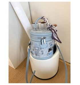 Dettaglio della borsa a secchiello azzurra con graffiti di orsi e foulard decorativo