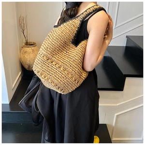 Handmade woven straw shoulder bag featuring wave textures and contrast black trim details