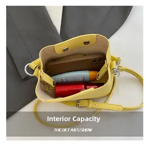 Vue intérieure du sac seau en cuir jaune grainé montrant une grande capacité de rangement
