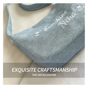 Gros plan détaillé d'un sac bandoulière en denim bleu avec broderie blanche de qualité