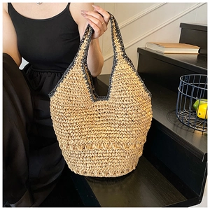 Detailed top view of handmade straw tote bag with black woven handles and trims
