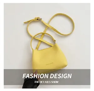 Détail d'un sac à main jaune en cuir PU grainé avec une longue bandoulière réglable