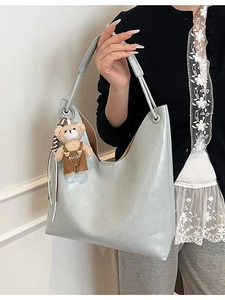 Light blue faux leather tote bag with a cute brown teddy bear keychain accessory