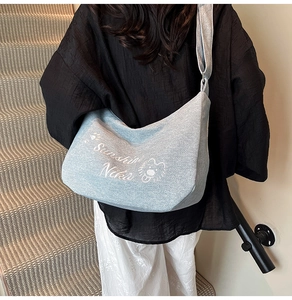 Vue arrière d'un mannequin portant le grand sac cabas en toile bleu clair avec lion