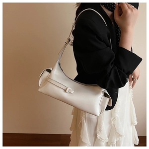 Détail de la texture en cuir blanc brillant et de la bandoulière réglable du sac à main