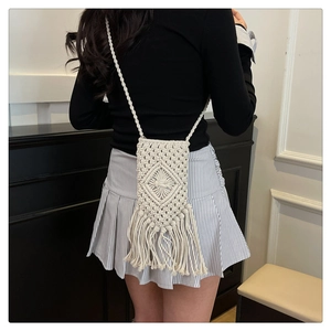 Détail du petit sac macramé blanc avec motifs en losange et élégantes franges longues