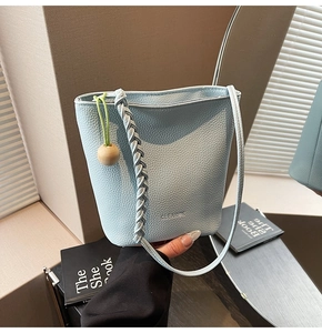 Detail of light blue bucket bag with braided handle and CLEAROK logo branding