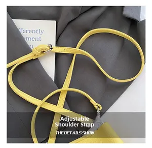 Détail de la bandoulière réglable en cuir jaune à motif litchi avec boucle en métal argenté