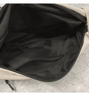 Vue détaillée de l'intérieur du sac beige avec doublure noire et poche zippée pratique
