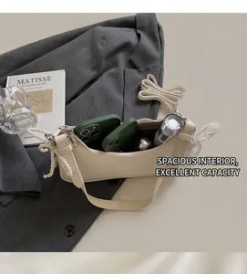 Dettaglio dell'interno della borsa in pelle crema con spazio per telefoni e trucchi