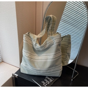 Close-up of green and white checkered tote bag featuring geometric embroidery details