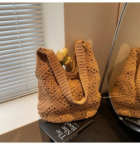Détail d'un sac à bandoulière en crochet fait main avec un motif de tricot ajouré marron
