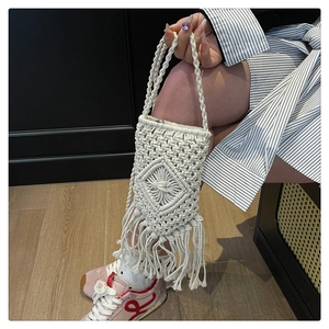 Détail macro du sac à bandoulière en coton blanc tissé à la main avec franges bohèmes