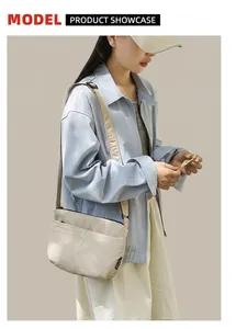 Modèle portant un sac beige minimaliste en nylon avec bandoulière réglable