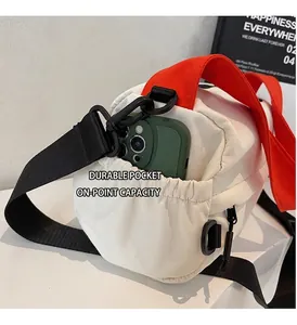 Detail of white nylon crossbody bag with side pocket showing phone storage capacity
