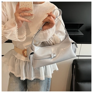 Detail of light blue-grey hobo bag with side pockets and adjustable strap shown on model