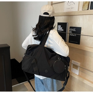 Detailaufnahme der schwarzen Nylon-Reisetasche mit abnehmbarem rundem Münzfach-Anhänger