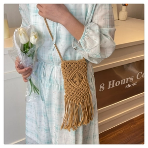 Détail d'un sac seau tissé à la main avec de longues franges et une texture bohème