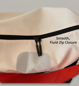 Detail of smooth double zippers and off-white canvas texture on a large crossbody bag