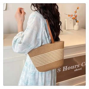 Detail of hand-woven straw tote bag featuring leather handles and summer resort styling