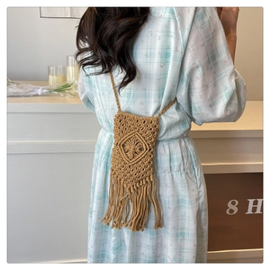 Détail de la texture tissée en losange et des longues franges sur un mini sac seau fait main
