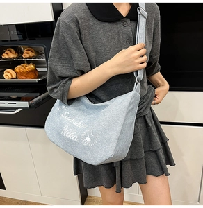 Détail de la boucle réglable et du motif en toile sur un grand sac fourre-tout