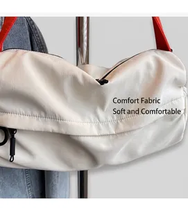 Detail of white textured shoulder bag with a bold red strap and metal zip detail