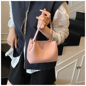 Vue détaillée du sac seau rose avec texture grainée litchi et logo de mode imprimé