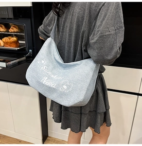 Sac hobo en denim bleu avec motif ours dessin animé et lettrage Sunshine Nika détaillé