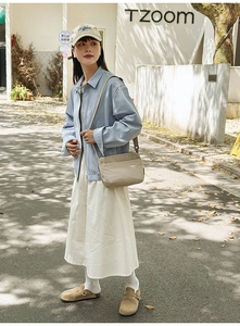 Détail d'un sac bandoulière beige en nylon léger avec texture imperméable et poches zippées