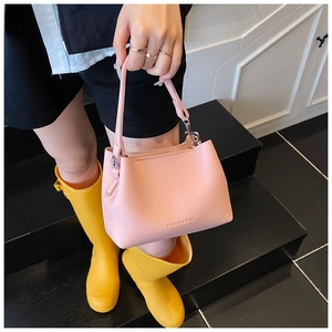 Gros plan sur un sac seau rose en cuir grainé avec texte embossé fashion and bags