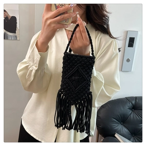 Détail du sac seau noir tissé à la main avec motif en losange et longues franges