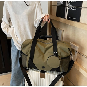 Olivgrüne Reisetasche auf einem Koffer mit Trolley-Aufsteckfunktion und Netztasche