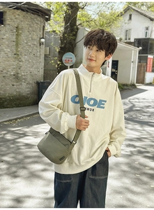 Détail de la maille gaufrée et du col montant zippé sur un sweat-shirt blanc cassé