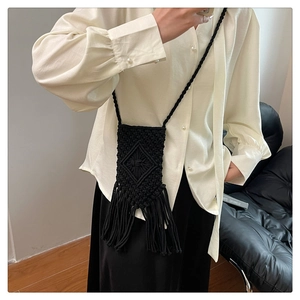 Détail du sac bandoulière en macramé noir avec motifs géométriques et franges