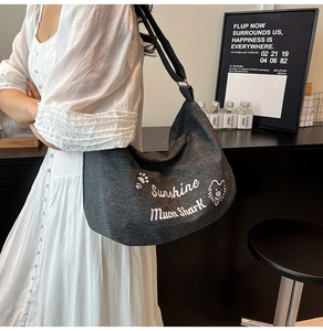 Détail du sac cabas vintage en toile avec texte brodé et motif de lion en dessin animé