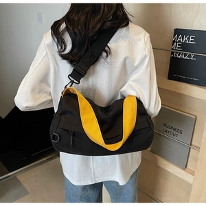 Close-up of yellow and black messenger bag with adjustable strap worn by a model