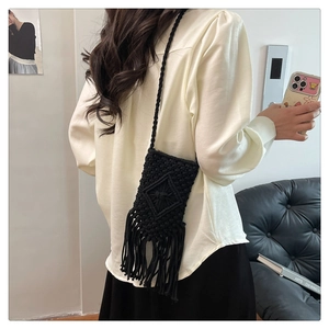 Détail du sac à bandoulière noir tressé main avec motif losange et longues franges