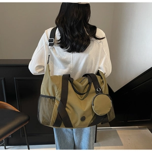 Detail der olivgrünen Reisetasche mit seitlicher Netztasche und rundem Münzfachanhänger