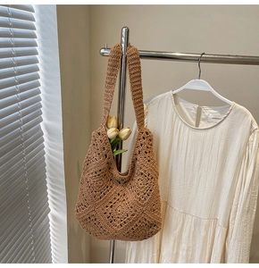 Détail d'un sac hobo marron tissé à la main avec motifs en losange et fleurs tulipes